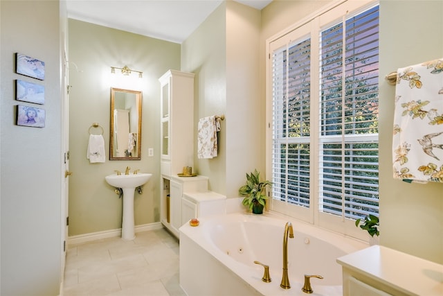 bathroom featuring tile patterned flooring, a washtub, and a healthy amount of sunlight