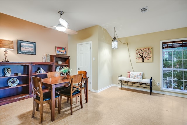 carpeted dining space with ceiling fan