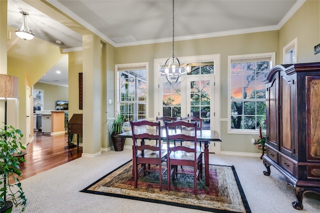 dining area with a notable chandelier, ornamental molding, and carpet flooring