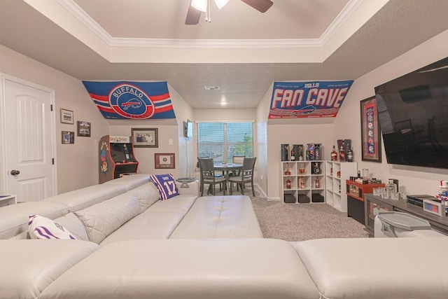 carpeted living room with crown molding, a raised ceiling, and ceiling fan