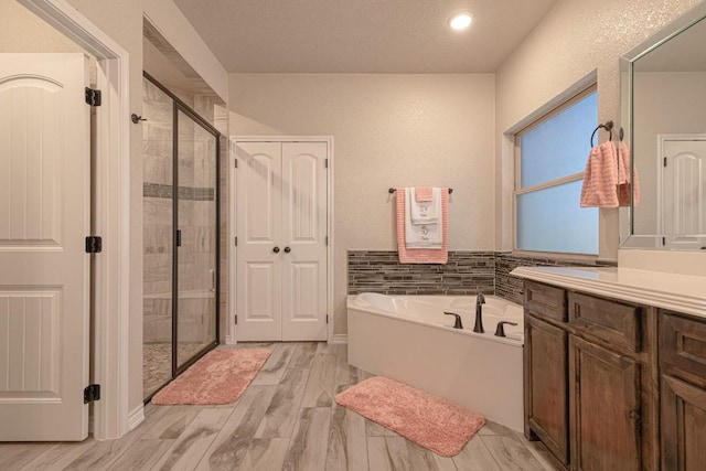 bathroom featuring vanity, plus walk in shower, and hardwood / wood-style floors