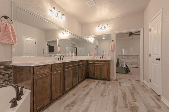 bathroom featuring vanity, hardwood / wood-style floors, a textured ceiling, and ceiling fan