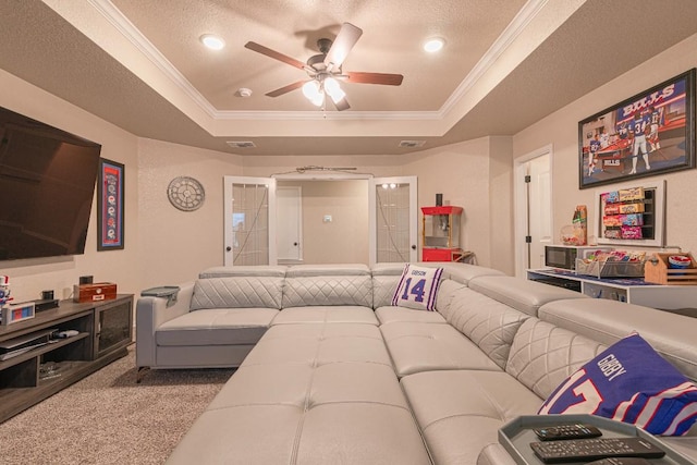 carpeted living room with a raised ceiling, crown molding, ceiling fan, and a textured ceiling