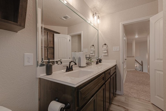 bathroom with vanity, hardwood / wood-style floors, and a textured ceiling