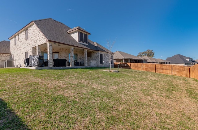 rear view of house with a yard and central AC