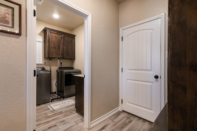 laundry area featuring independent washer and dryer and light hardwood / wood-style floors