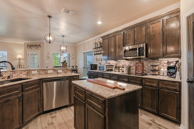 8000 Gold Dr, Killeen, TX 76542 - kitchen with stainless steel appliances, a sink, decorative backsplash, a textured ceiling, and dark brown cabinetry