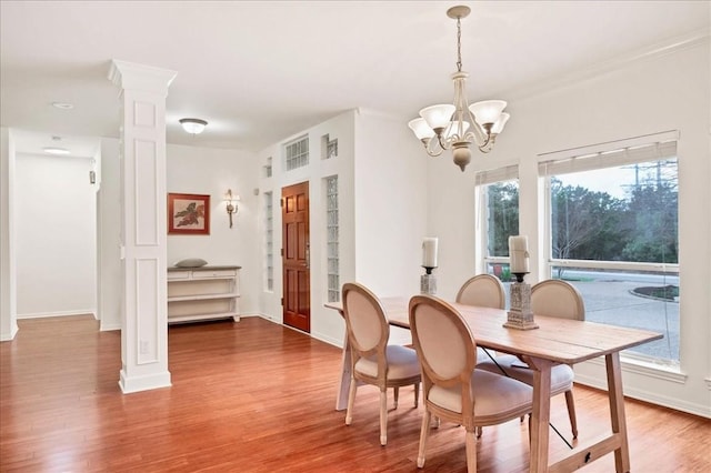 136 Clubhouse Dr, Lakeway, TX 78734 - dining room featuring a chandelier, wood finished floors, and ornate columns