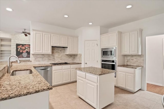 136 Clubhouse Dr, Lakeway, TX 78734 - kitchen featuring appliances with stainless steel finishes, light stone counters, decorative backsplash, white cabinetry, and ceiling fan