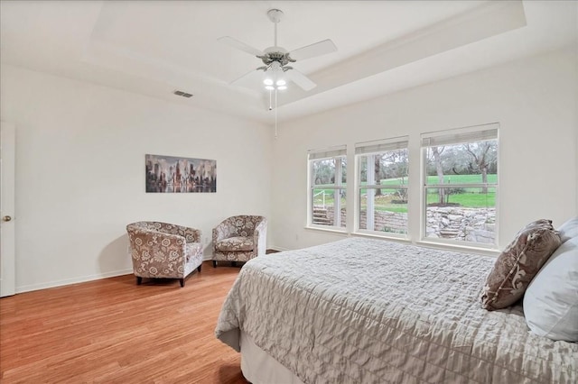 bedroom featuring a tray ceiling, hardwood / wood-style flooring, and ceiling fan