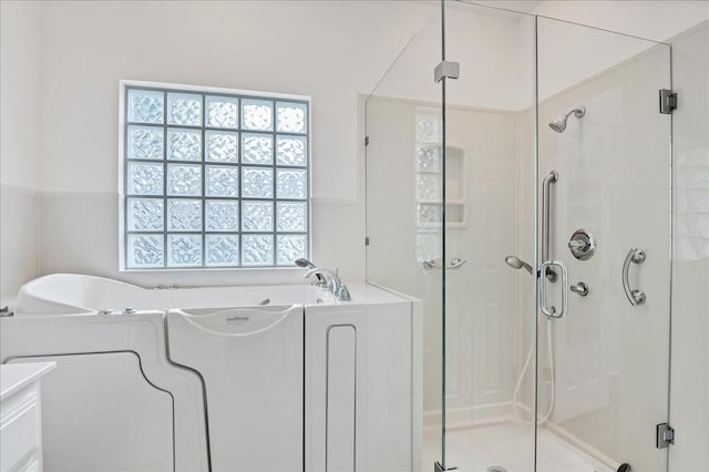 bathroom featuring shower with separate bathtub and vanity