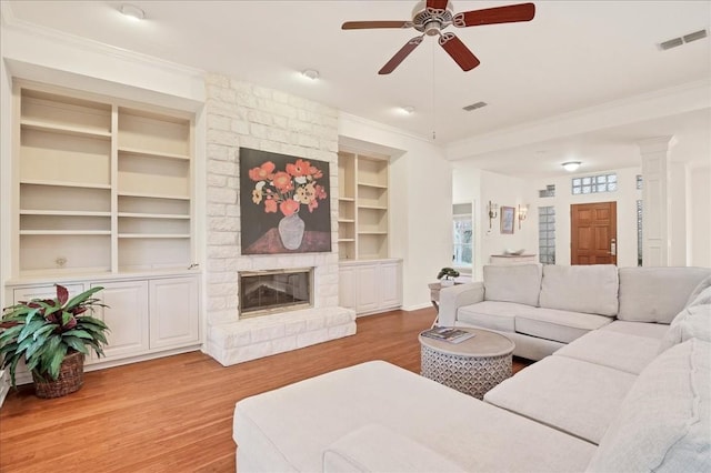 136 Clubhouse Dr, Lakeway, TX 78734 - living area with ceiling fan, wood finished floors, ornamental molding, built in features, and a fireplace