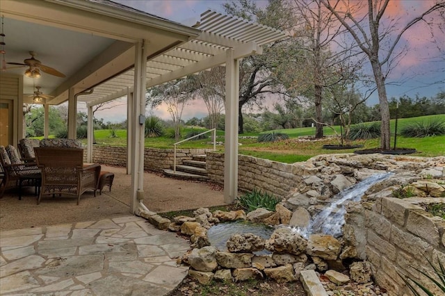 patio terrace at dusk with a pergola and ceiling fan