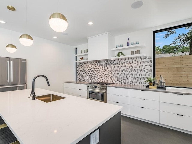 kitchen with sink, hanging light fixtures, stainless steel refrigerator, a kitchen island with sink, and backsplash