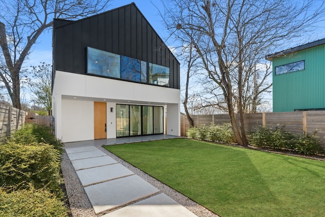 back of house with a yard and a fenced backyard