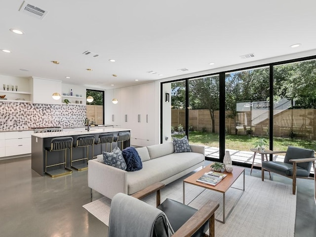 2903 E 14th St Unit 1, Austin, TX 78702 - living room featuring finished concrete floors, recessed lighting, and a wall of windows