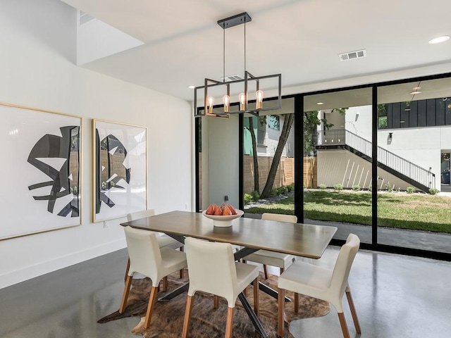 2903 E 14th St Unit 1, Austin, TX 78702 - dining space with concrete flooring, a chandelier, baseboards, a wall of windows, and recessed lighting