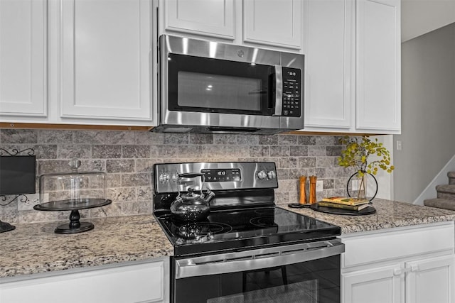 2221 Clove Ct, Temple, TX 76501 - kitchen featuring tasteful backsplash, light stone countertops, white cabinets, and appliances with stainless steel finishes