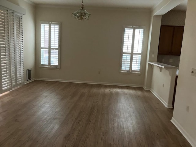 103 Wild Rose Dr, Georgetown, TX 78633 - unfurnished dining area with dark wood-style flooring, healthy amount of natural light, baseboards, a chandelier, and ornamental molding
