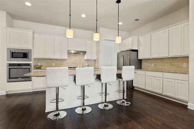 kitchen with white cabinetry, stainless steel appliances, and hanging light fixtures