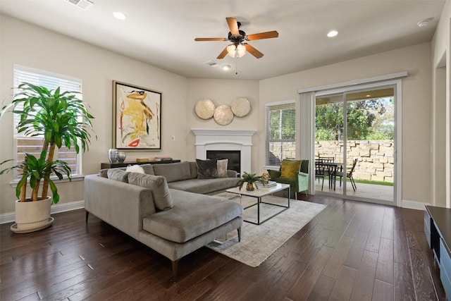 living room featuring ceiling fan and dark hardwood / wood-style flooring