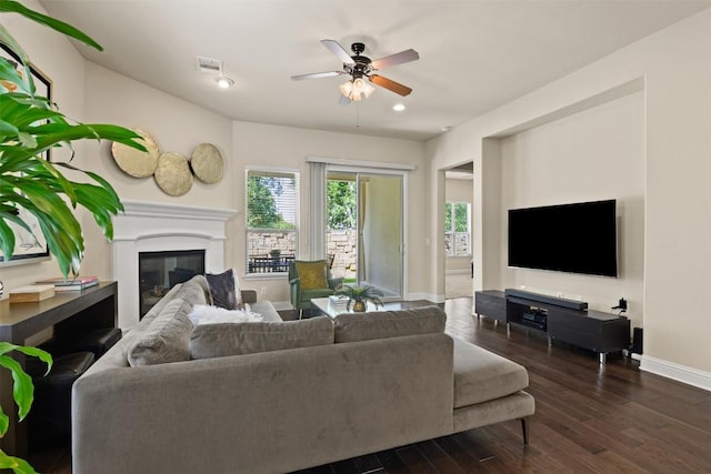 living room featuring dark wood-type flooring and ceiling fan