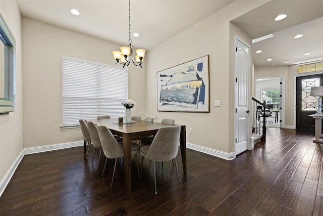 dining area featuring dark wood-type flooring and a notable chandelier