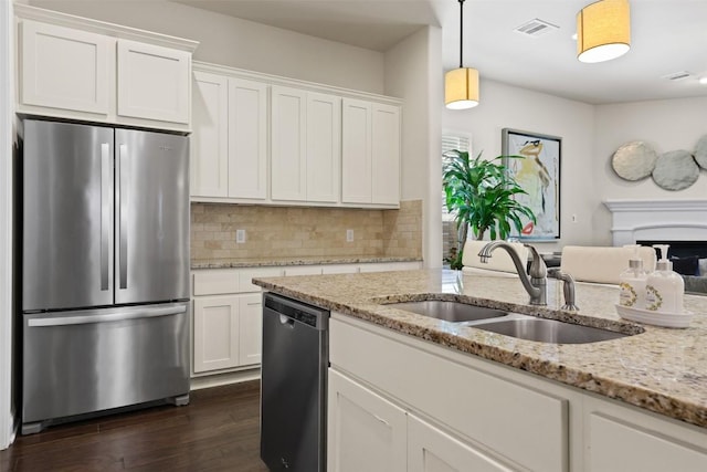 kitchen featuring light stone counters, sink, white cabinets, and appliances with stainless steel finishes