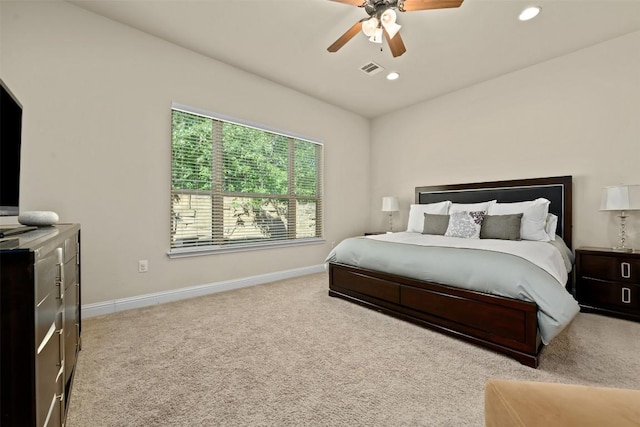 bedroom with vaulted ceiling, light colored carpet, and ceiling fan