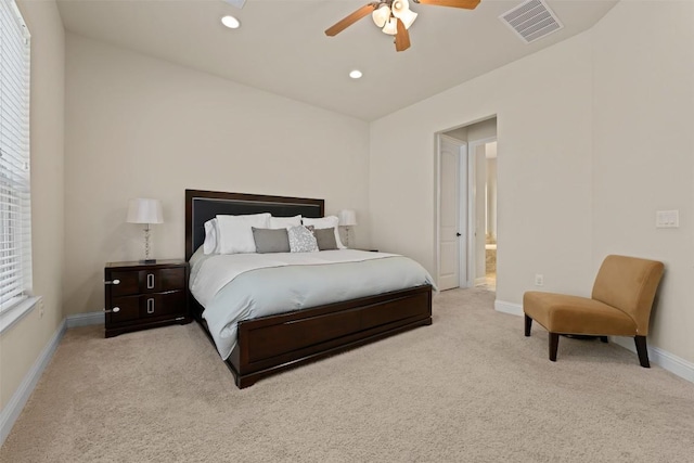 bedroom featuring light carpet, ceiling fan, and ensuite bathroom