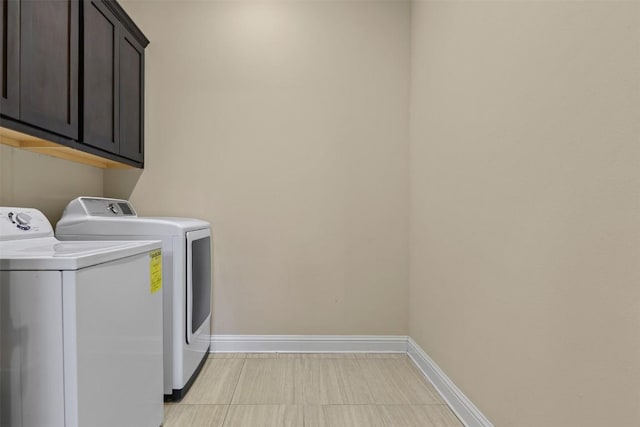 laundry room with washer and dryer and cabinets