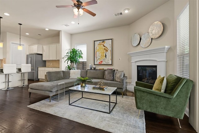 living room with dark hardwood / wood-style floors and ceiling fan