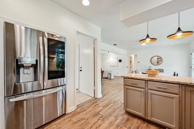 kitchen with pendant lighting, light wood-type flooring, light stone countertops, and stainless steel refrigerator with ice dispenser