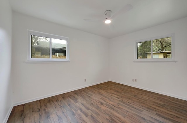 unfurnished room with dark wood-type flooring, ceiling fan, and a wealth of natural light