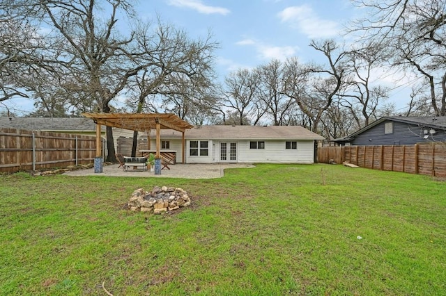 rear view of property featuring french doors, a patio area, a lawn, a pergola, and a fire pit