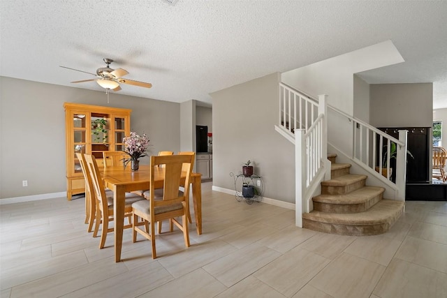 dining room featuring ceiling fan and a textured ceiling