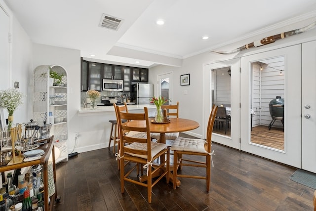 dining space featuring ornamental molding and dark wood-type flooring