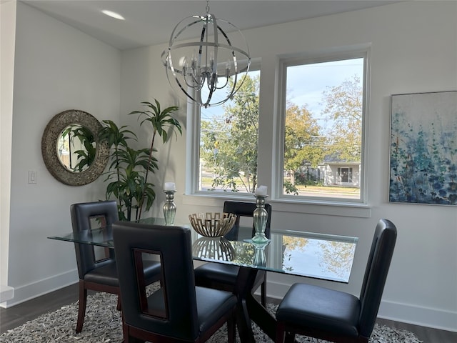 dining room with dark hardwood / wood-style floors and an inviting chandelier