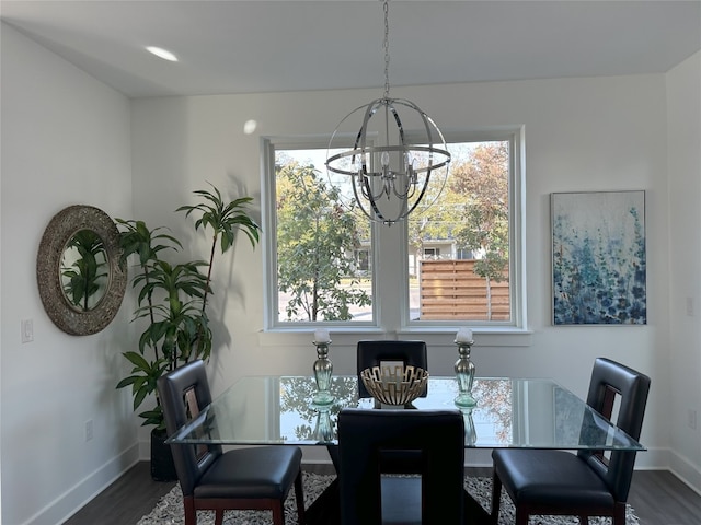 dining room featuring a notable chandelier, dark wood-type flooring, and a healthy amount of sunlight