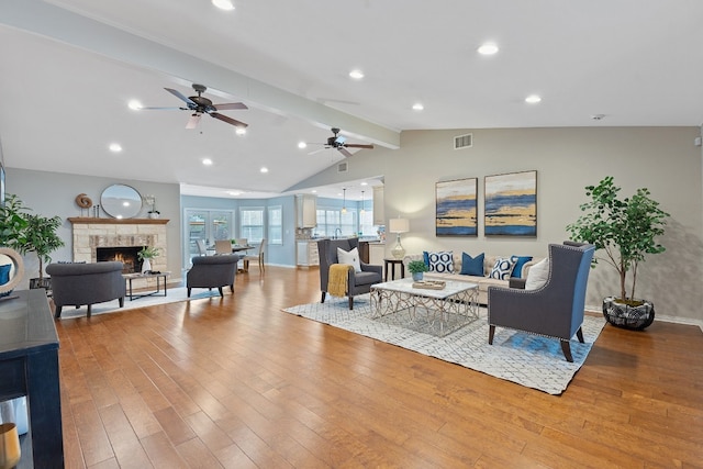 living room featuring ceiling fan, vaulted ceiling with beams, and light hardwood / wood-style floors