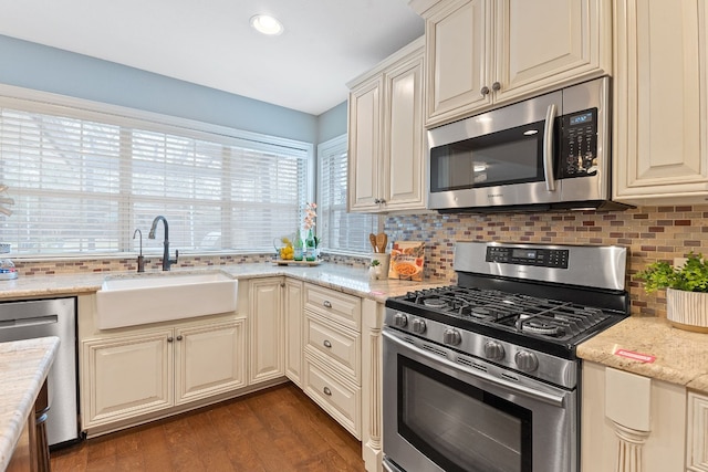 1526 Shenandoah Dr, Cedar Park, TX 78613 - kitchen with appliances with stainless steel finishes, a sink, decorative backsplash, cream cabinets, and dark wood-style floors