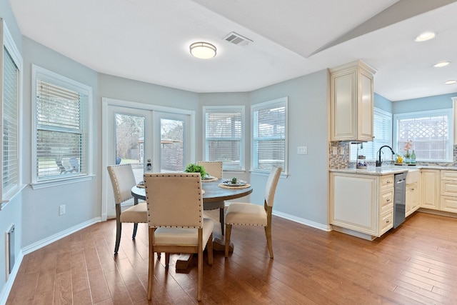 dining area with plenty of natural light, light hardwood / wood-style flooring, and french doors