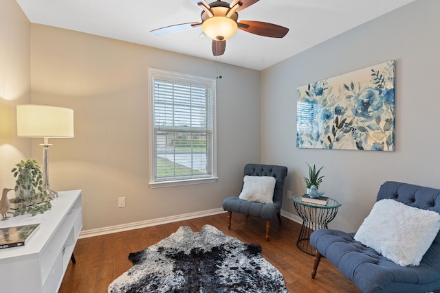living area featuring dark wood-type flooring and ceiling fan