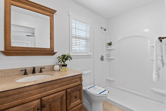 bathroom with walk in shower, vanity, tile patterned floors, and toilet