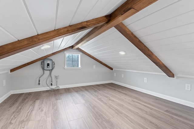 additional living space featuring lofted ceiling with beams and light hardwood / wood-style flooring