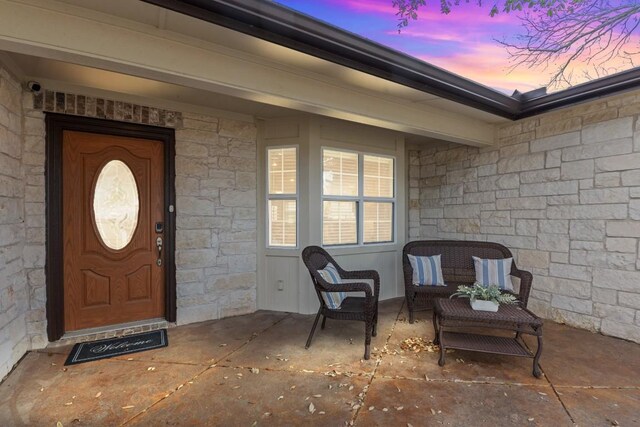exterior entry at dusk featuring a patio