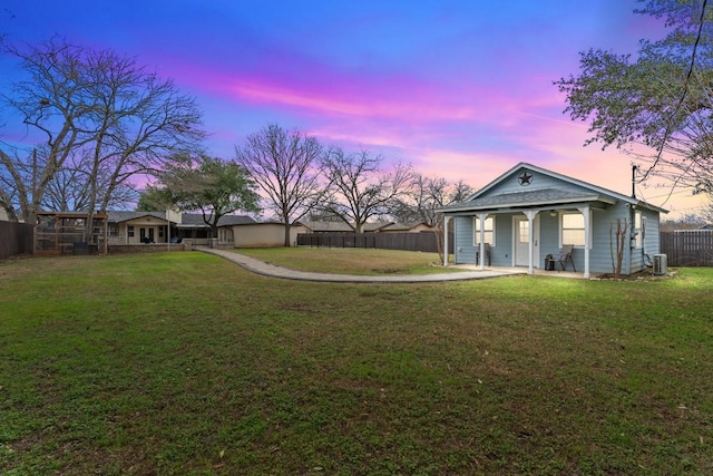 yard at dusk with a porch and central AC unit