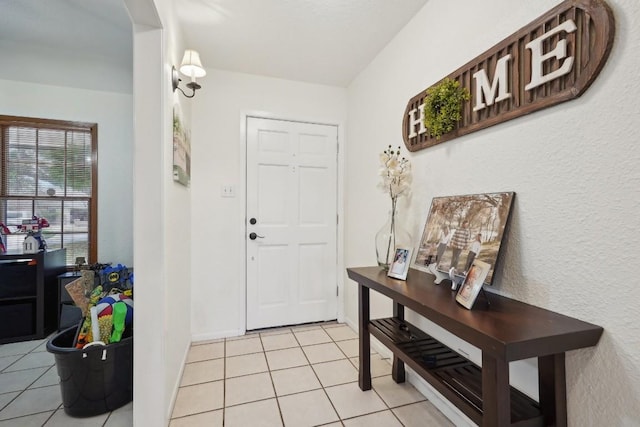 foyer entrance featuring baseboards and light tile patterned flooring