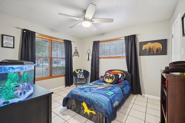 bedroom featuring multiple windows, a textured ceiling, and ceiling fan