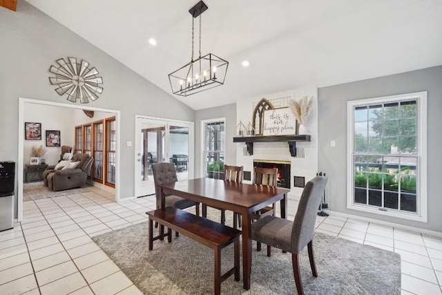 dining area featuring light tile patterned flooring, recessed lighting, baseboards, and a warm lit fireplace